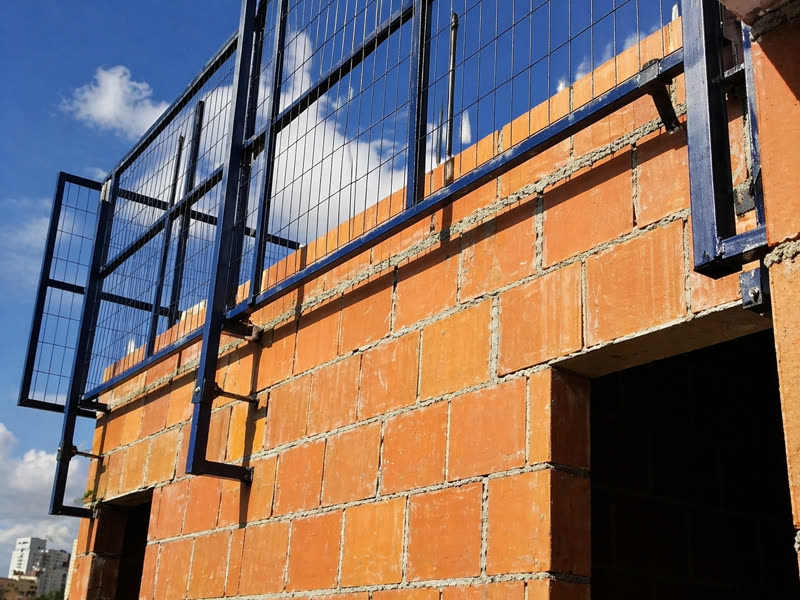Proteção perimetral em malha metálica contornando laje elevada
