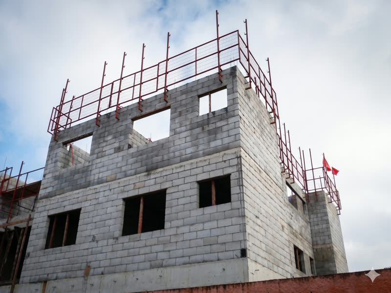 Guarda-corpo provisório em malha metálica aplicado no perímetro de obra térrea
